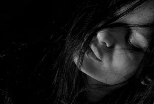 Ritratto in bianco e nero di una donna con capelli sul viso.
