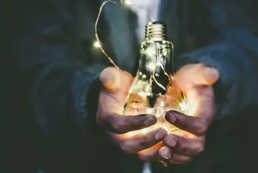 Mani che tengono una lampadina con luci a LED.