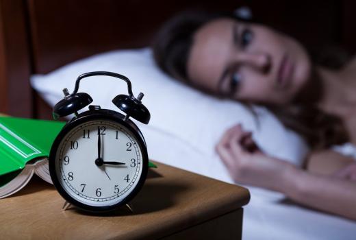 Donna insonne guarda la sveglia alle 3 del mattino.